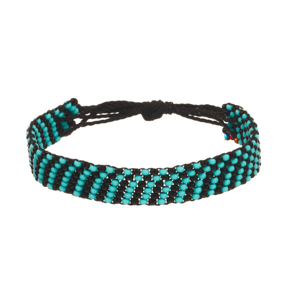 A beaded ArtiKen bracelet, handmade in Kenya, in support for PTSD awareness, in the colors of turquoise and black beads. 