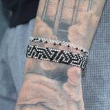 black adjustable bracelet with a silver labyrinth design. handmade in Kenya