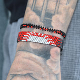 black, gray, and red adjustable bracelet with a white sun depicting a sunrise. handmade in Kenya