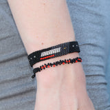 black, silver, and red adjustable bracelet with various dots, lines, and rectangles representing different blocks of time, based on bead count. handmade in Kenya