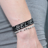 thin silver stretchy bracelet that reads "believe" in black morse code. handmade in Kenya