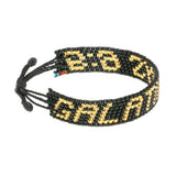 A handmade beaded bracelet from ArtiKen created in Kenya displaying the text Galatians 6:9 in black and gold.