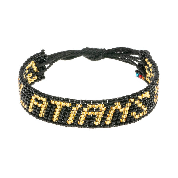 A handmade beaded bracelet from ArtiKen created in Kenya displaying the text Galatians 6:9 in black and gold.