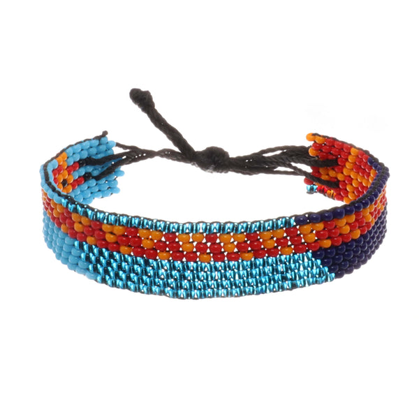 A handmade in Kenya, ArtiKen bracelet on a blue background displays a Giraffe all the way around it. 