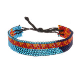 A handmade in Kenya, ArtiKen bracelet on a blue background displays a Giraffe all the way around it. 