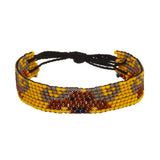 A beaded ArtiKen bracelet, handmade in Kenya, with a solid dark yellow background, hosting the savage African Buffalo. 