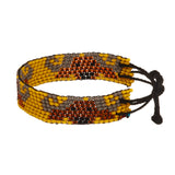 A beaded ArtiKen bracelet, handmade in Kenya, with a solid dark yellow background, hosting the savage African Buffalo.