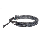 A handmade in Kenya ArtiKen bracelet displays steel colored beads. 