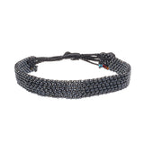 A handmade in Kenya ArtiKen bracelet displays steel colored beads. 
