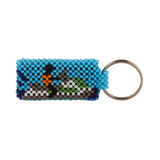 A beaded ArtiKen keychain, handmade in Kenya, displays a blue background and person on a jetski, in black, gray, orange, red, green, white.