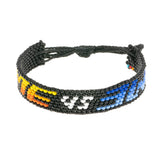 A handmade beaded bracelet from ArtiKen created in Kenya displaying the text Me vs Me in black, orange and blue.