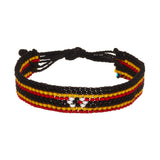 A beaded ArtiKen bracelet, handmade in Kenya, in Uganda flag colors, black, yellow, red, and white. 