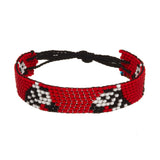 A beaded ArtiKen bracelet, handmade in Kenya, with a red background, hosting the famously striped black and white Zebra. 