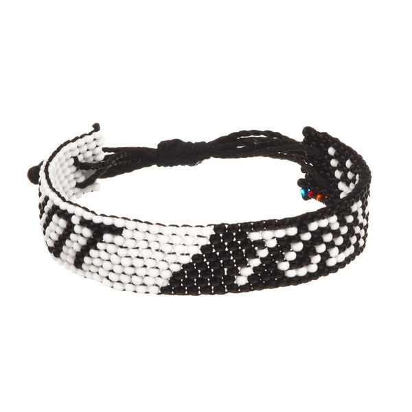 A beaded ArtiKen bracelet, handmade in Kenya, with a half black and half white back ground, suggests NOT TODAY in opposite colored text. 